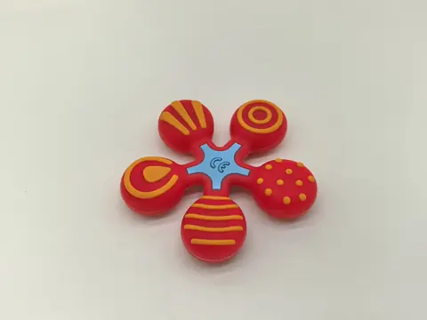 Five-petal silicone part in red and yellow with a light blue centre.